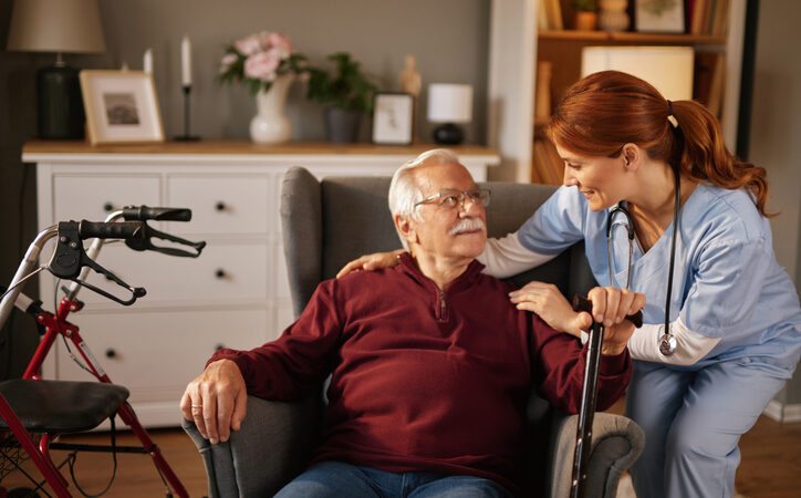 Older man at home with a live-in carer, talking together in familiar surroundings