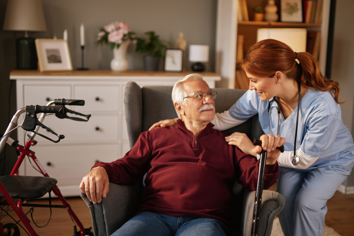 Older man at home with a live-in carer, talking together in familiar surroundings