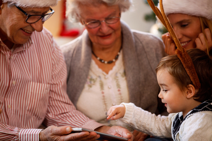 Adult daughter spending time with elderly parent at home after Christmas, talking together